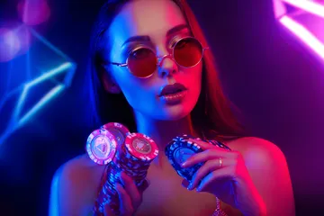 A woman smiling by bright slot machines showing lucky symbols, showcasing the exciting slot offerings at BAJI200.